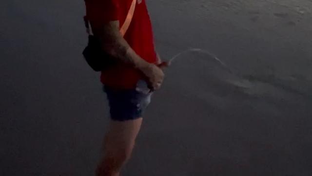 Tirando Uma Água Do Joelho Na Praia 
