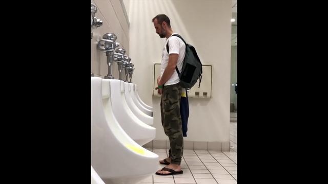 Flagras de machos Mijando em banheiro Pubiico